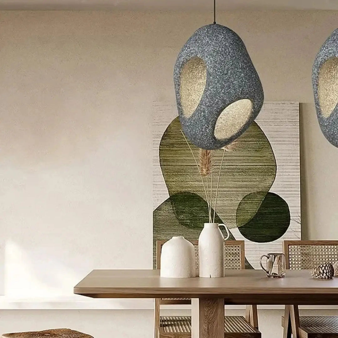Suspension luminaire cavia gris texturé avec deux découpes ovales révélant une lueur intérieure chaude design aux