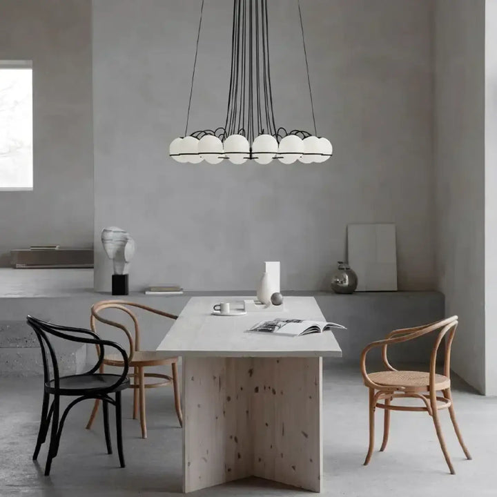 Suspension luminaire cloudis avec plusieurs globes sphériques blancs suspendus par cordons noirs et structure métallique centrale