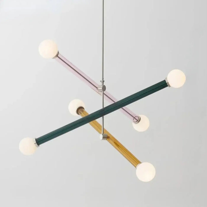 Modern geometric suspension luminaire design with intersecting matte green, lavender, and natural wood rods ending in frosted globes