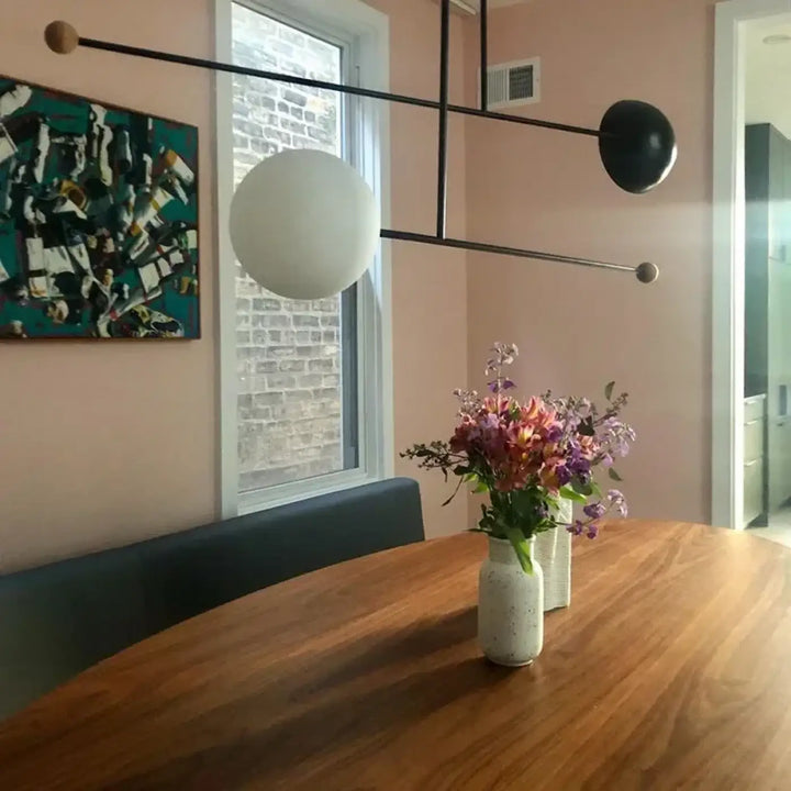 Suspension luminaire axis avec vase en céramique blanche tachetée et bouquet de fleurs violettes et roses