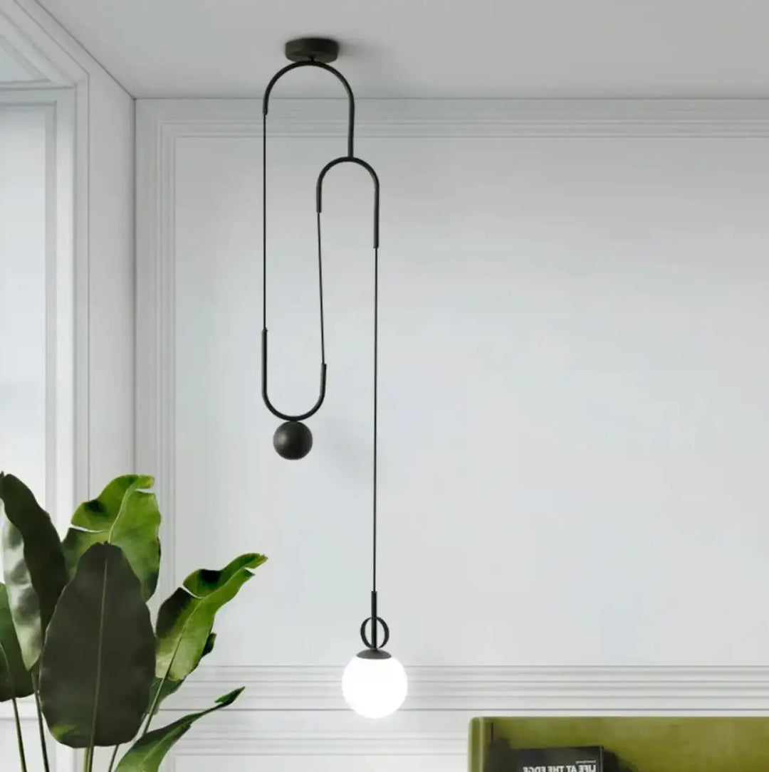 Suspension luminaire pendora en métal noir avec design courbé et ampoule sphérique pour un luminaire design moderne