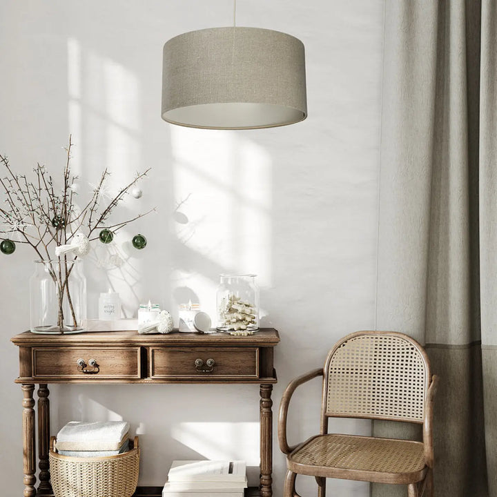 Suspension luminaire design kaki en lin beige avec abat-jour cylindrique suspendue au-dessus d’une console en bois