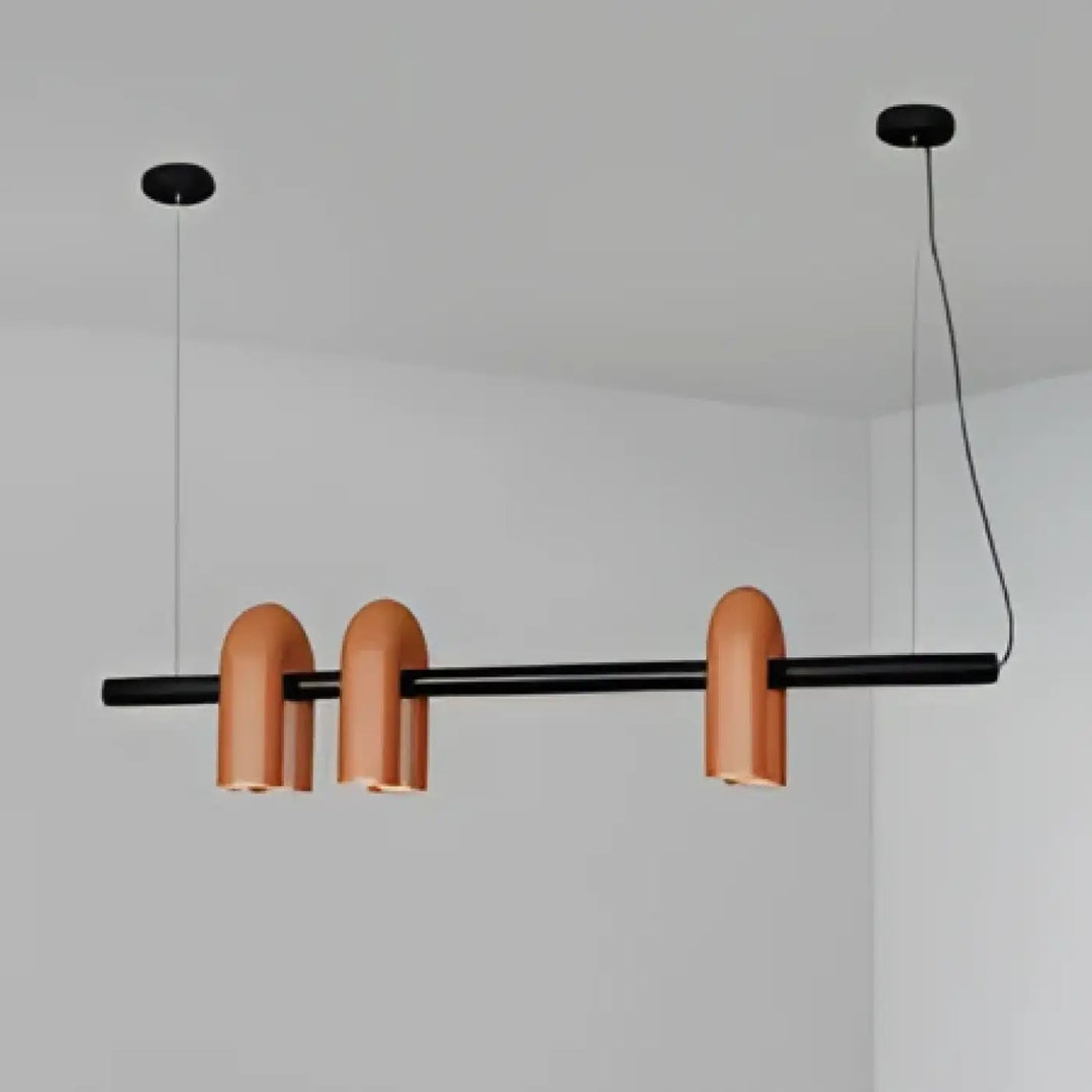 Suspension luminaire onda en cuivre avec barre noire horizontale et trois lampes cylindriques pour un design moderne