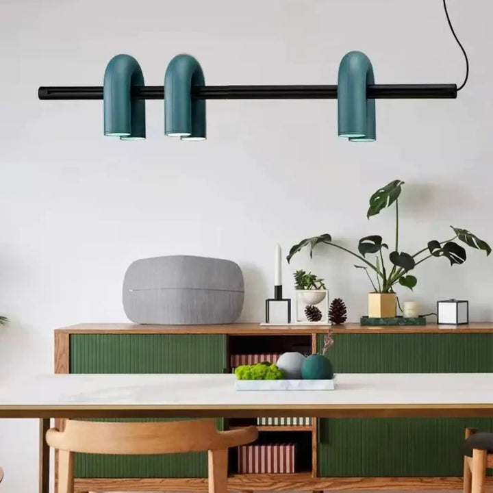 Suspension luminaire onda avec trois abat-jours tubulaires incurvés couleur sarcelle suspendus à une barre noire