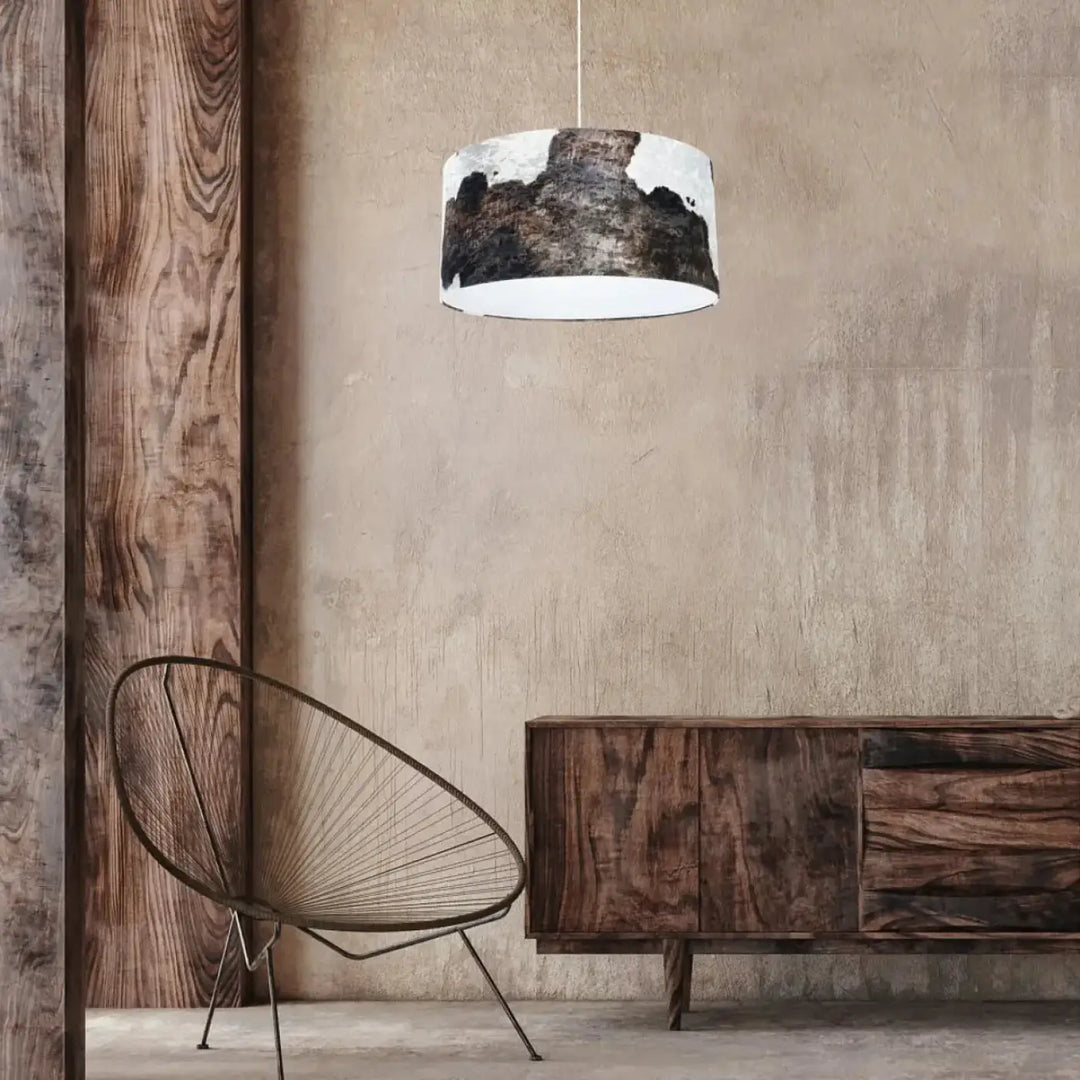 Suspension luminaire marron blanc cylindrique avec intérieur blanc et motif peau de vache noir et blanc suspendu par cordon fin