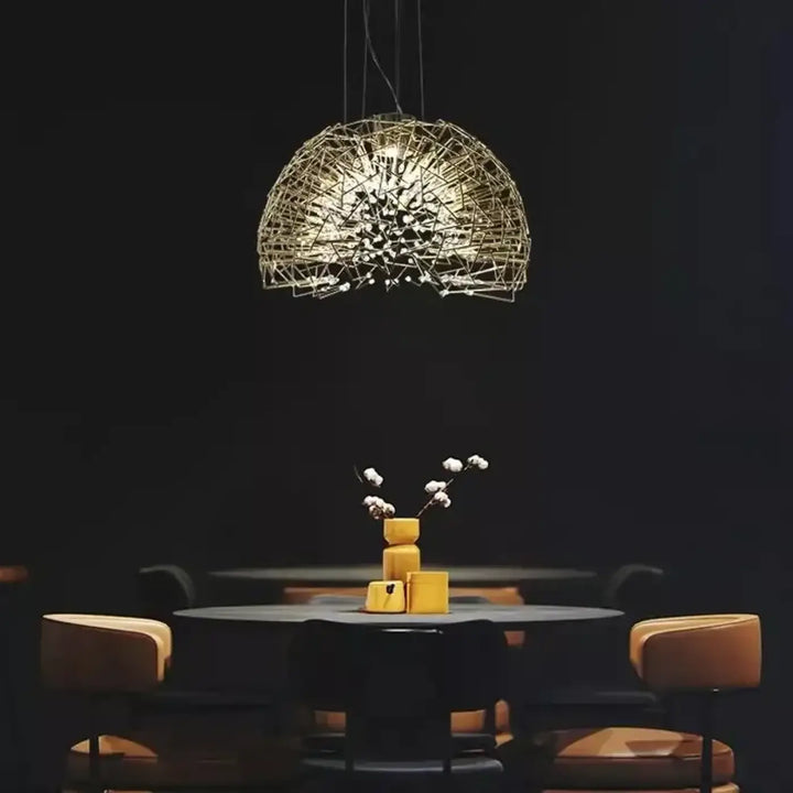 Suspension luminaire texia dorée en fil métallique avec design sphérique complexe suspendue au-dessus d’une table sombre