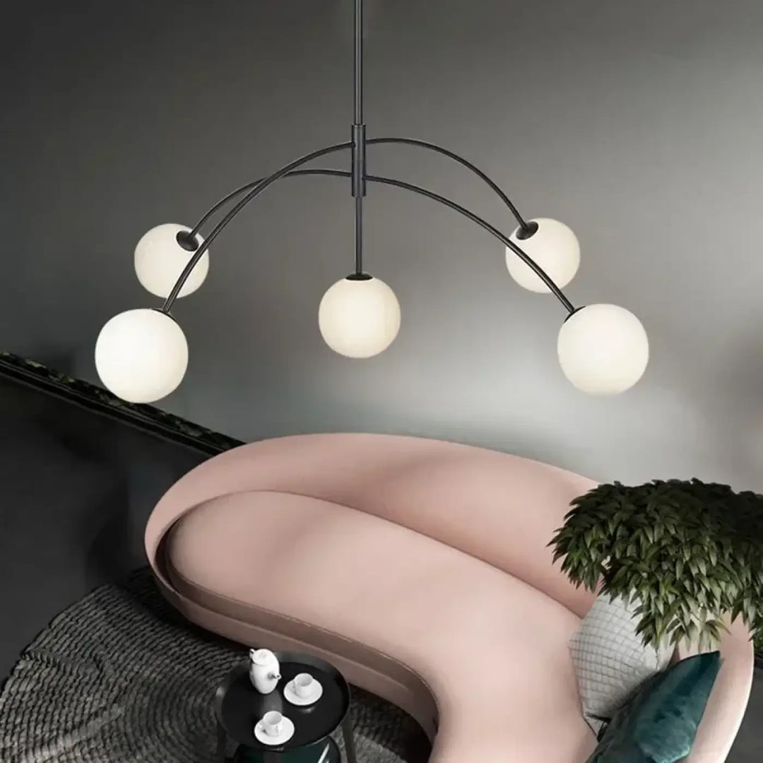 Suspension luminaire laithy en métal noir moderne avec cinq globes en verre givré offrant une lumière douce pour salle à manger