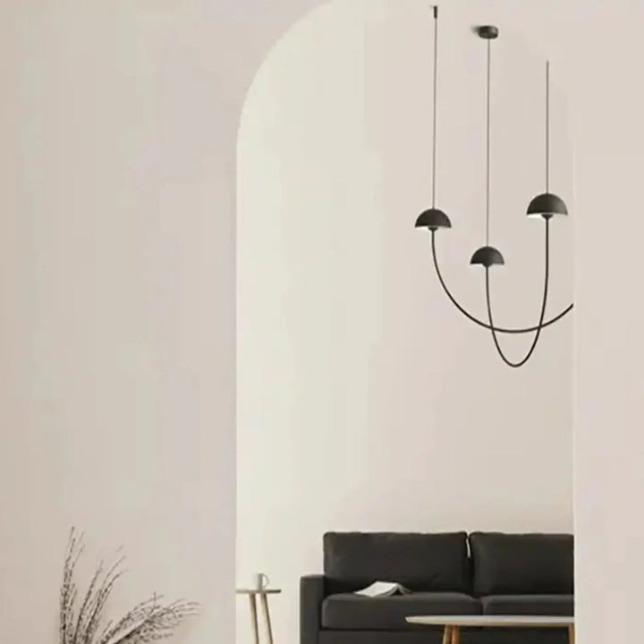 Suspension luminaire rotulia design noire aux trois abat-jours en dôme noir minimaliste suspendus par fils courbés fines