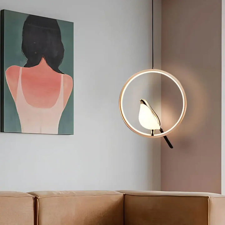 Suspension luminaire fody avec halo lumineux et abat-jour oiseau éclairé dans un cadre circulaire doré moderne