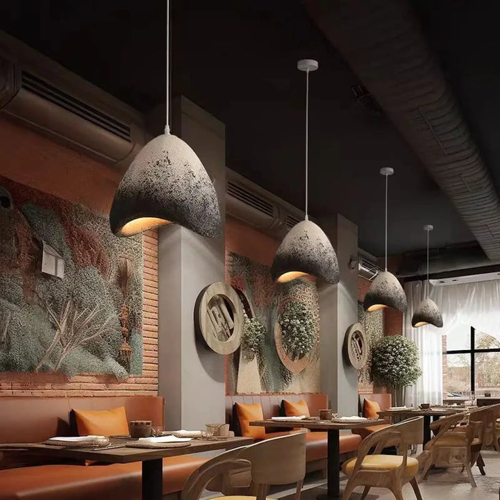 Suspension luminaire alma en résine granuleuse avec finition mate grise et lumière chaude intérieure design élégant