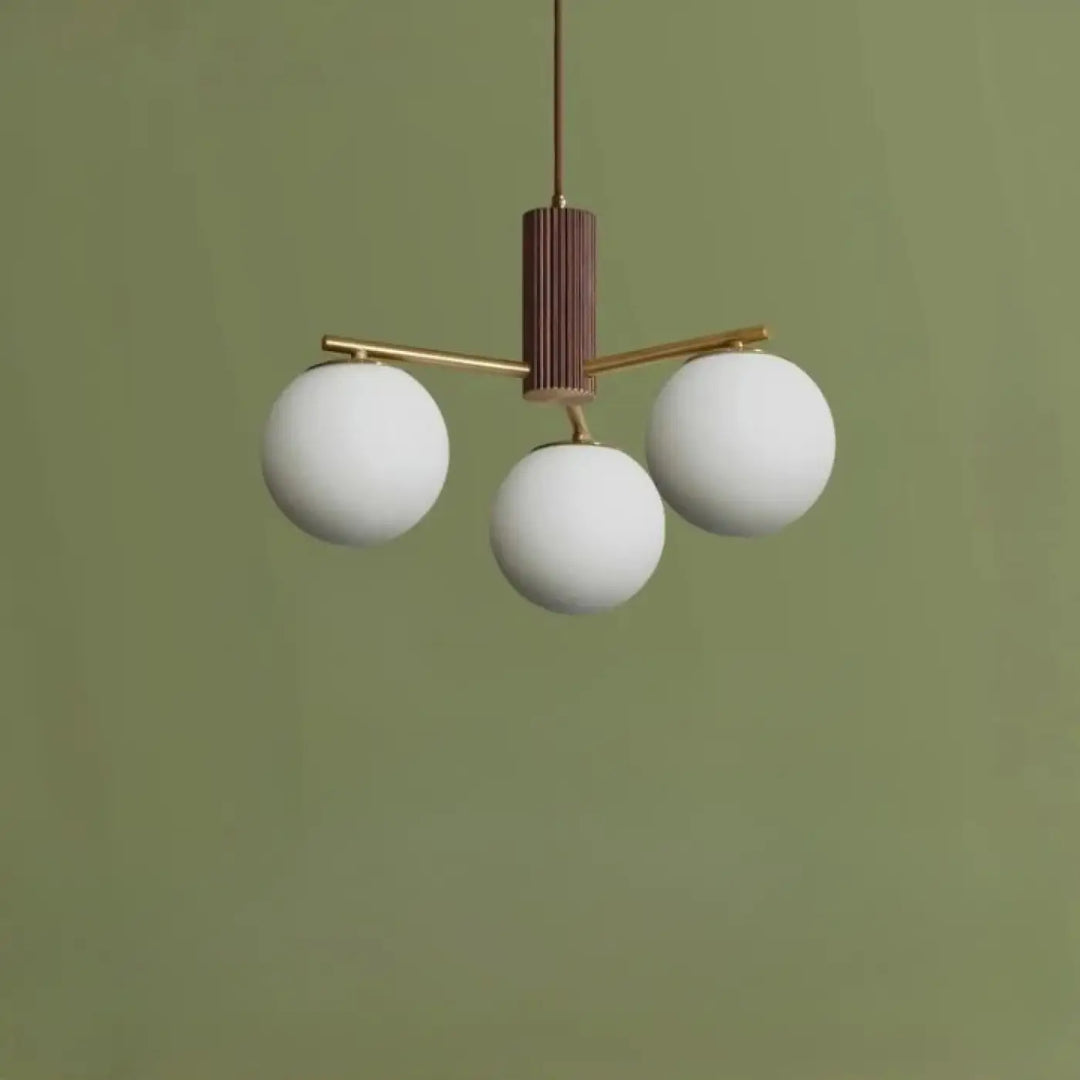 Suspension luminaire juglys avec trois sphères lumineuses blanches en verre et corps cylindrique vertical en laiton