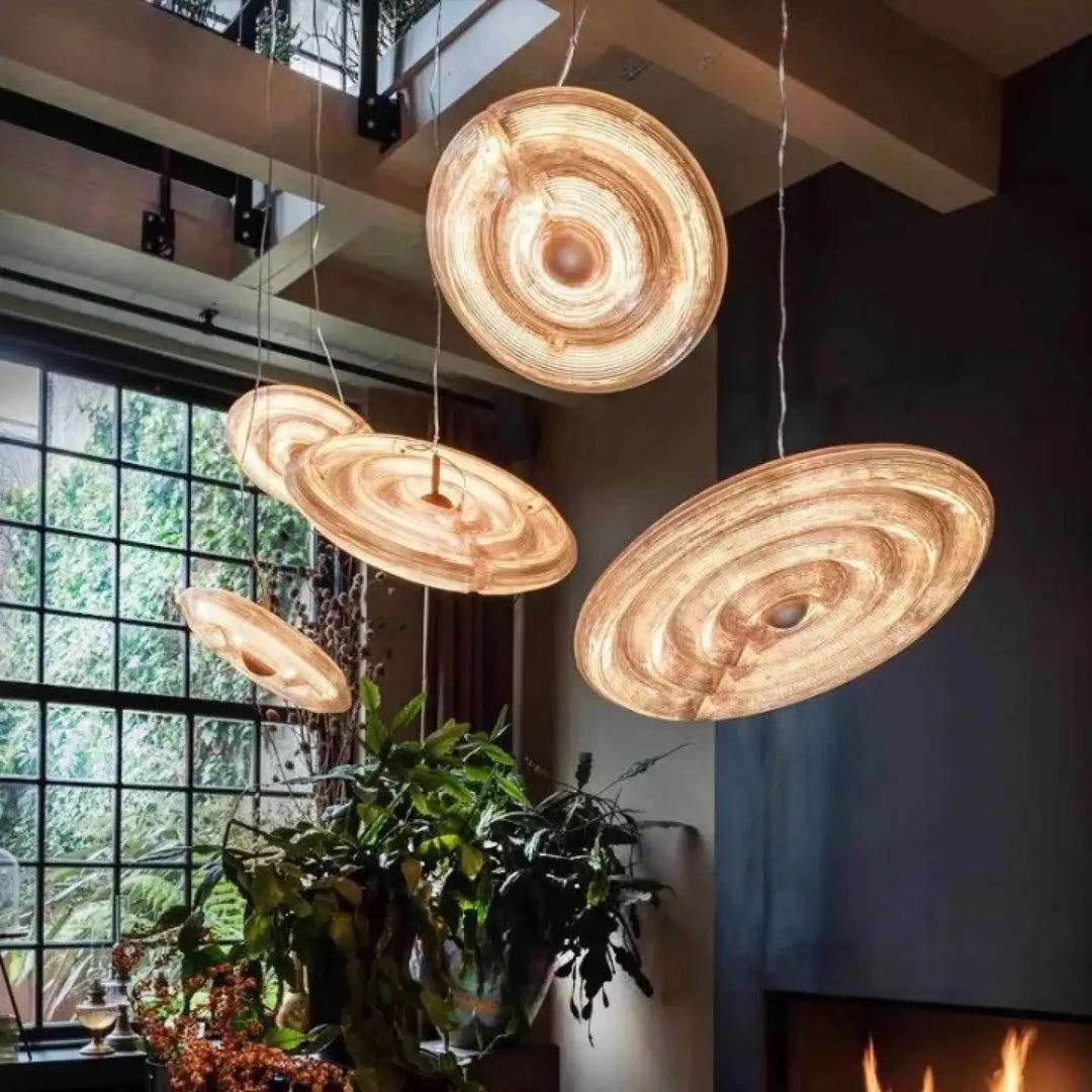 Suspension luminaire pyra en bois circulaire avec motifs concentriques et reflets ambrés en verre sculpté chaud