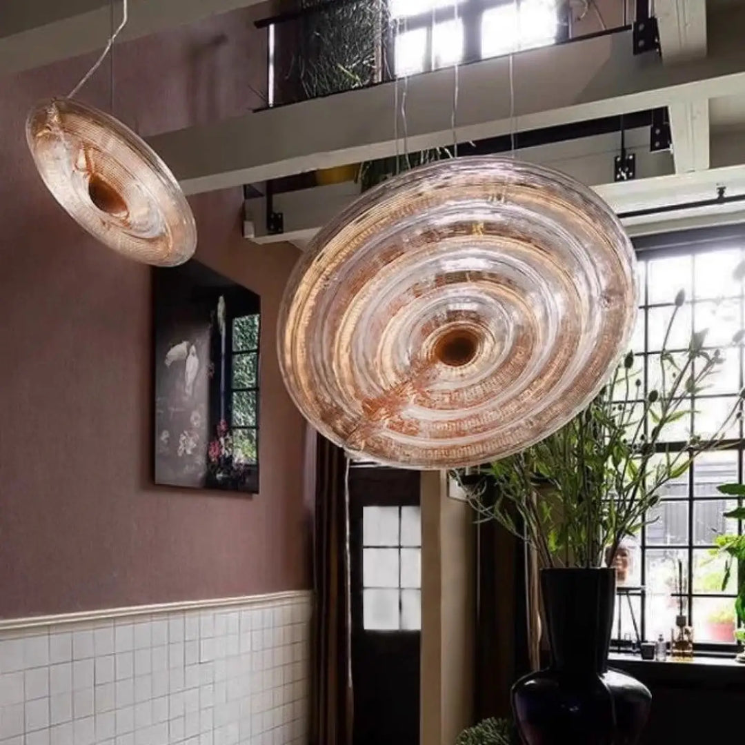 Suspension luminaire pyra en verre sculpté translucide ambré avec réflets ambrés et rainures circulaires concentriques
