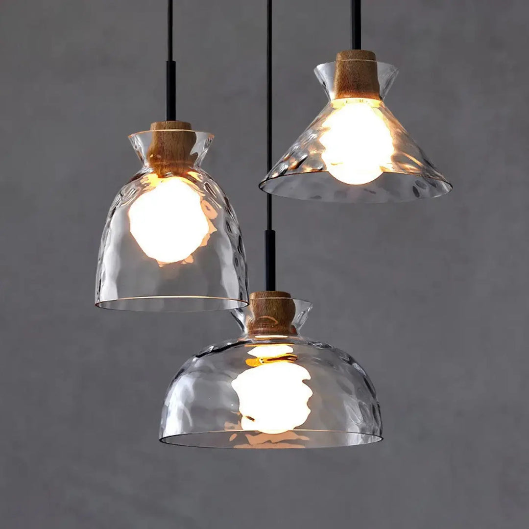 Trois suspensions luminaires tukai avec abat-jour en verre transparent texturé et accents en liège naturel