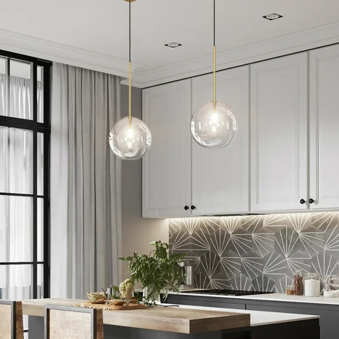 Suspension luminaire doré avec une boule en verre transparente

