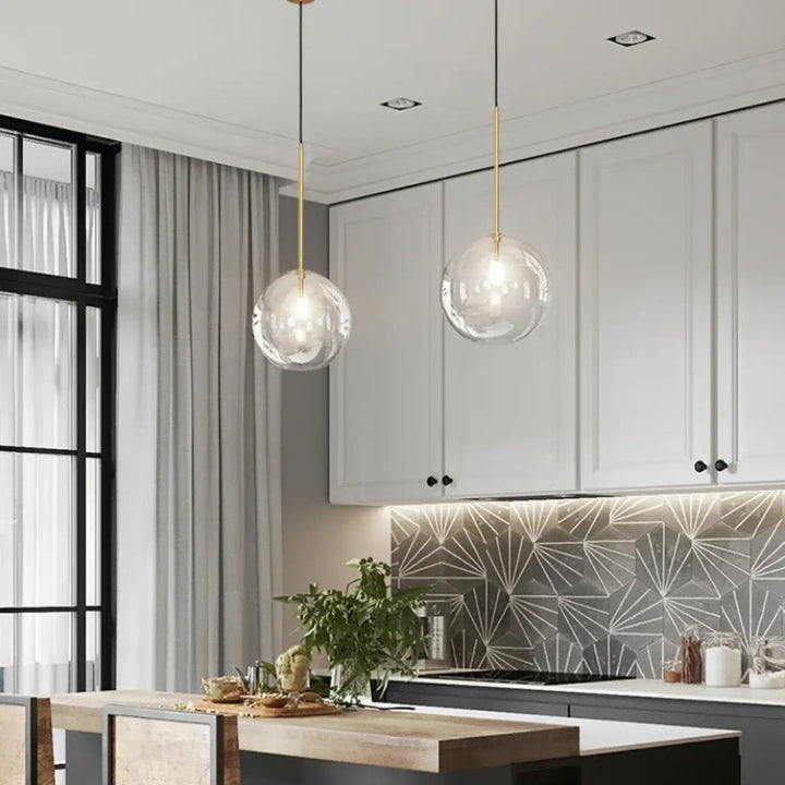Suspension luminaire doré avec une boule en verre transparente

