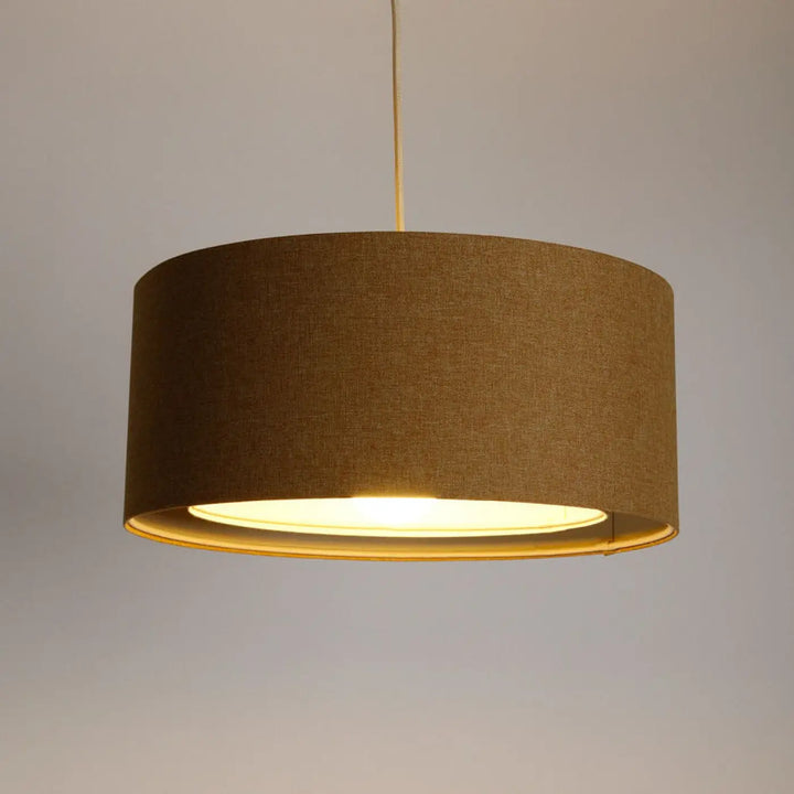 Suspension luminaire écru cylindrique avec abat-jour en tissu marron texturé et lumière chaude diffuse