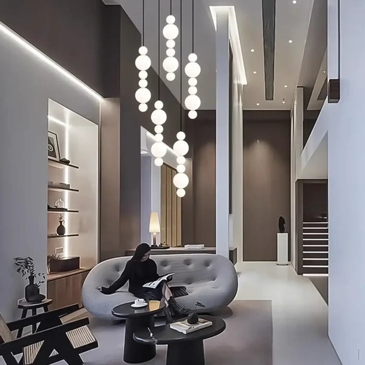 Suspension luminaire oxyo avec boules opalines en verre dépoli en chute verticale pour un éclairage moderne et élégant