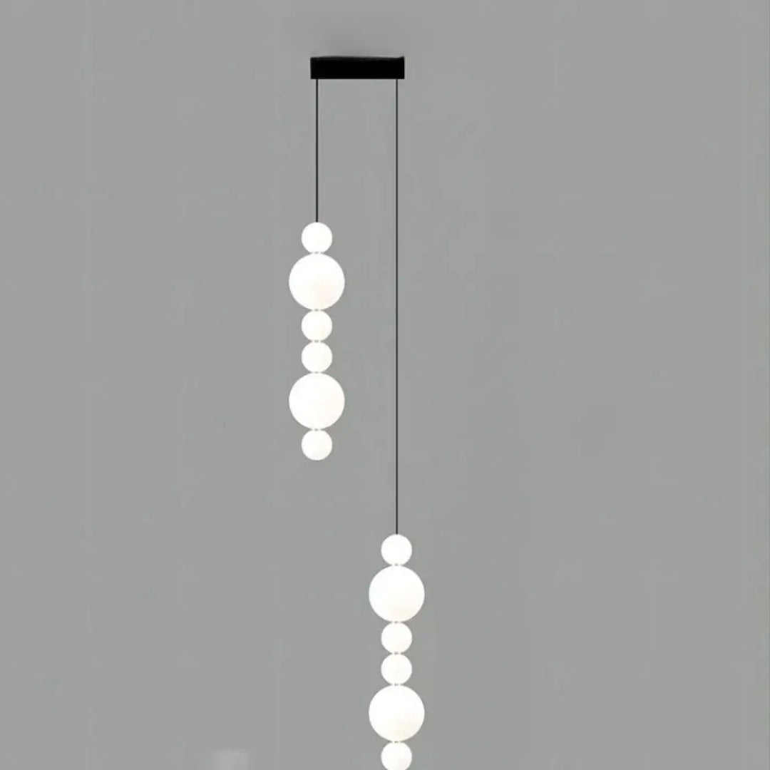 Suspension luminaire oxyo avec chutes verticales de boules opalines en verre dépoli et support de plafond noir élégant