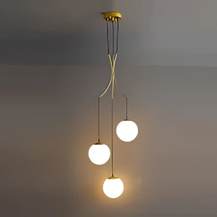 Suspension luminaire umami en métal doré avec trois ampoules sphériques en verre suspendues par bras courbés fins