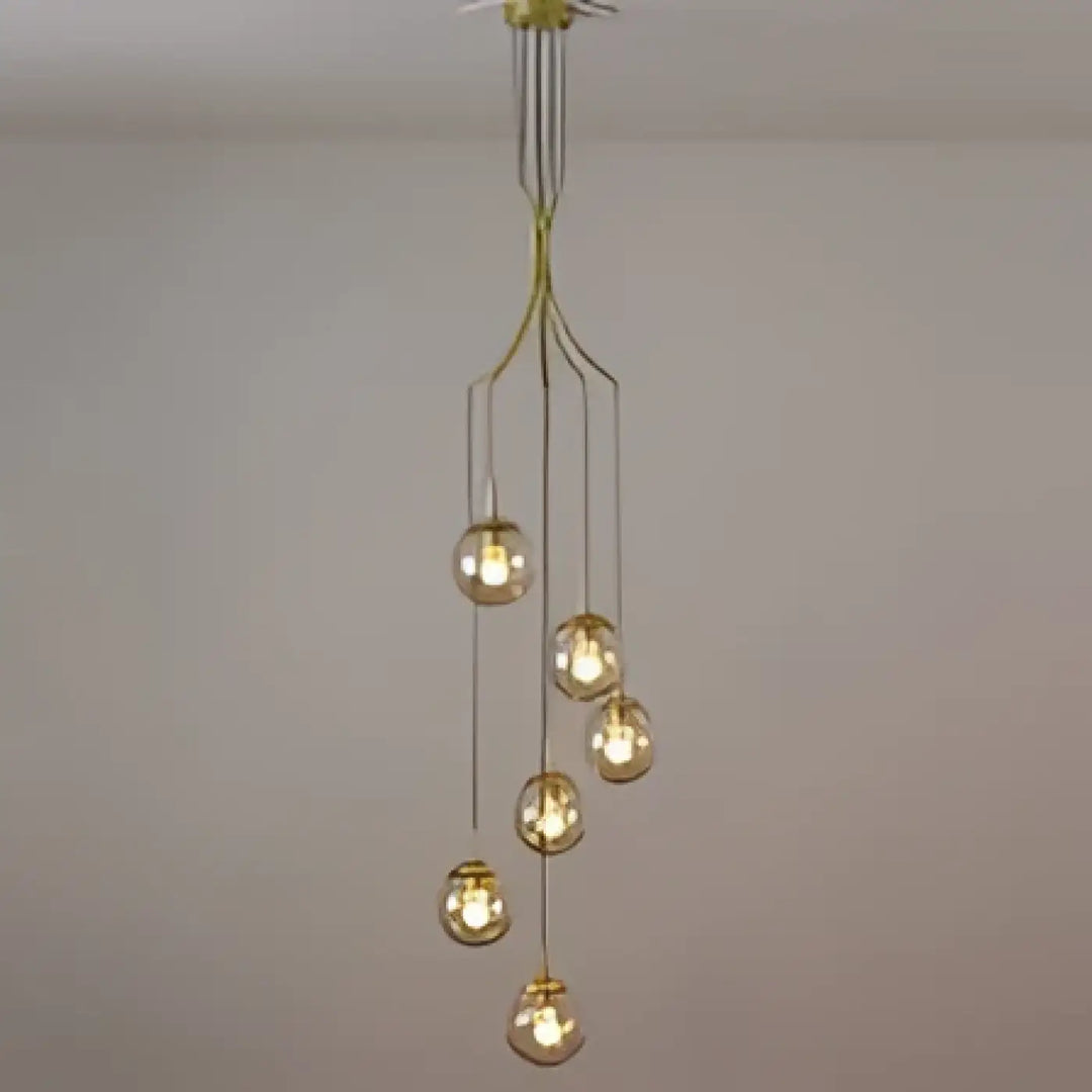 Suspension luminaire umami en métal doré avec plusieurs globes en verre sphériques suspendus à un support central