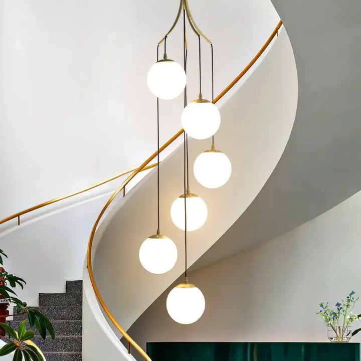 Suspension luminaire umami en laiton avec cinq globes en verre dépoli en cascade pour éclairage moderne