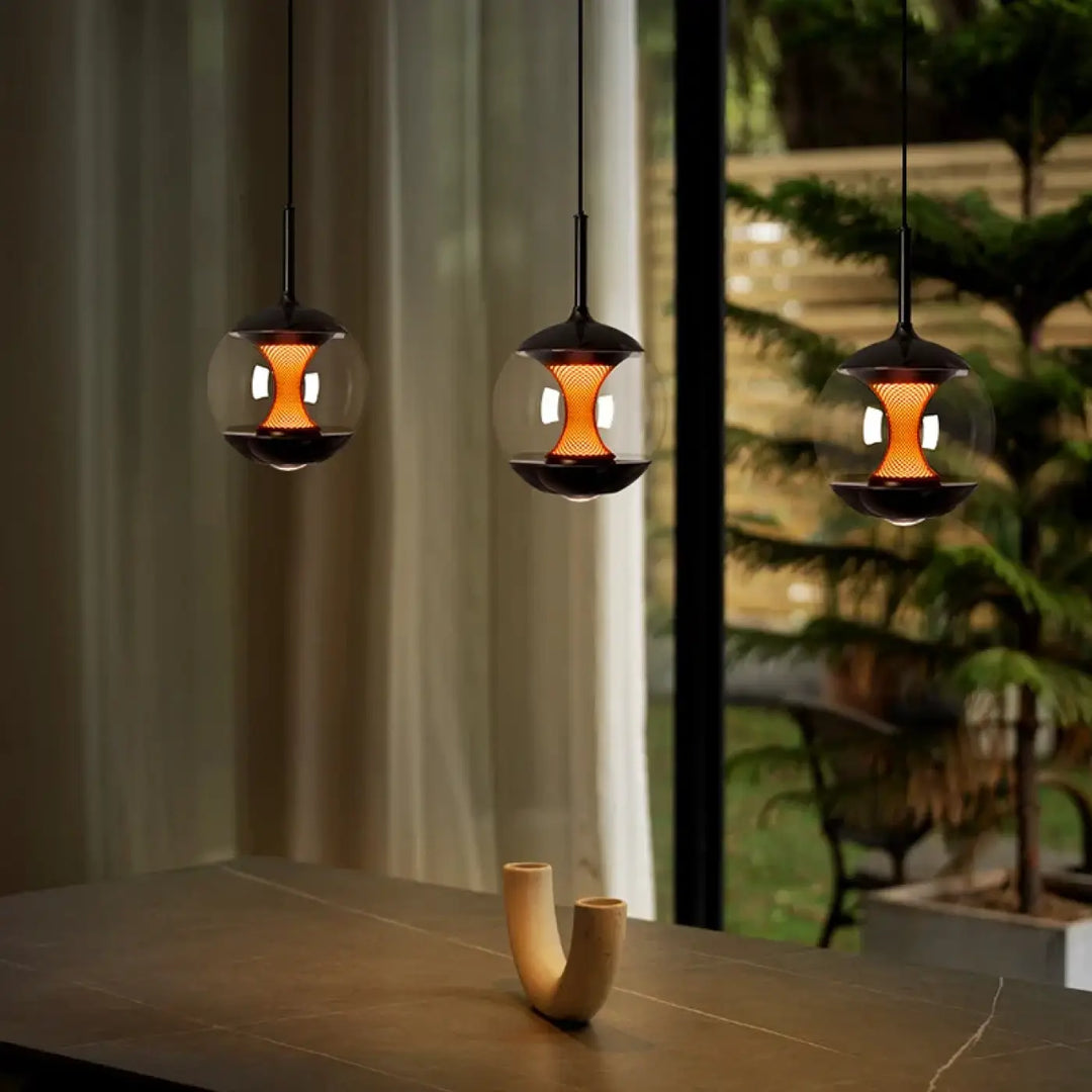 Suspension luminaire nexus avec trois luminaires suspendus noirs en métal et globes en verre clair à luminosité variable