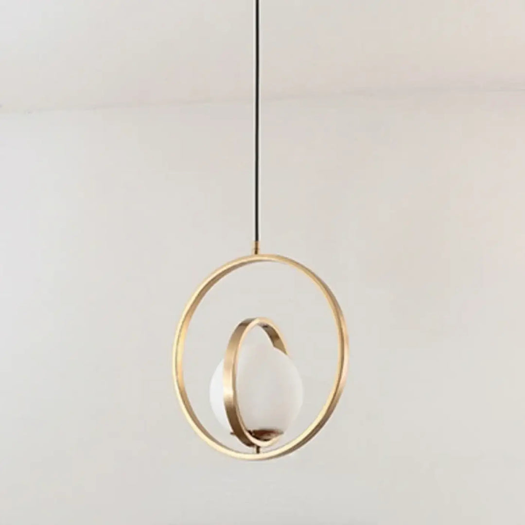Suspension luminaire élégante luménia avec cadre métallique doré et globe en verre dépoli minimaliste