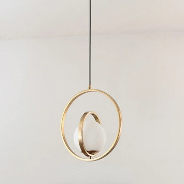 Suspension luminaire élégante luménia avec cadre métallique doré et globe en verre dépoli minimaliste
