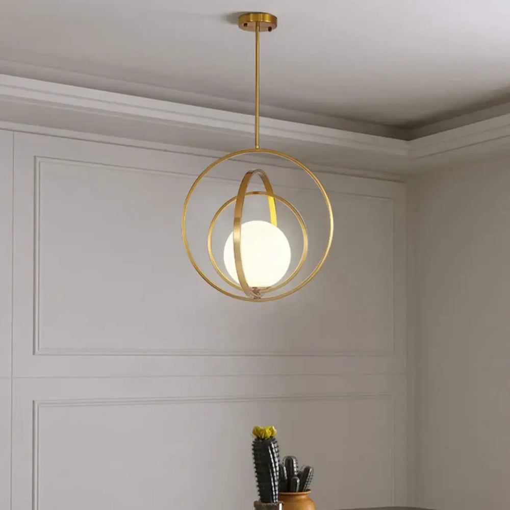 Suspension luminaire élégante gold-toned avec anneaux circulaires et globe en verre dépoli par lumina