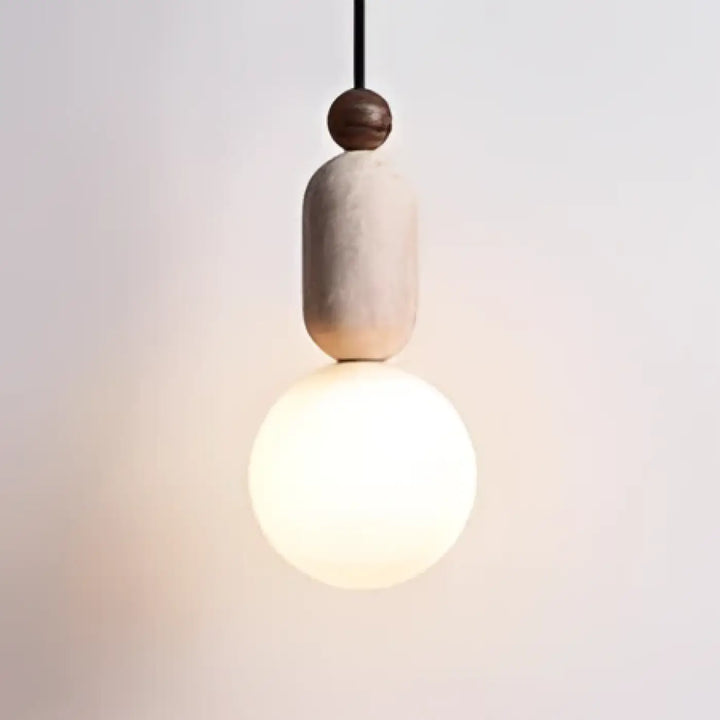 Suspension luminaire sora avec abat-jour cylindrique beige mat en pierre texturée et ampoule blanc chaud suspendue par cordon noir