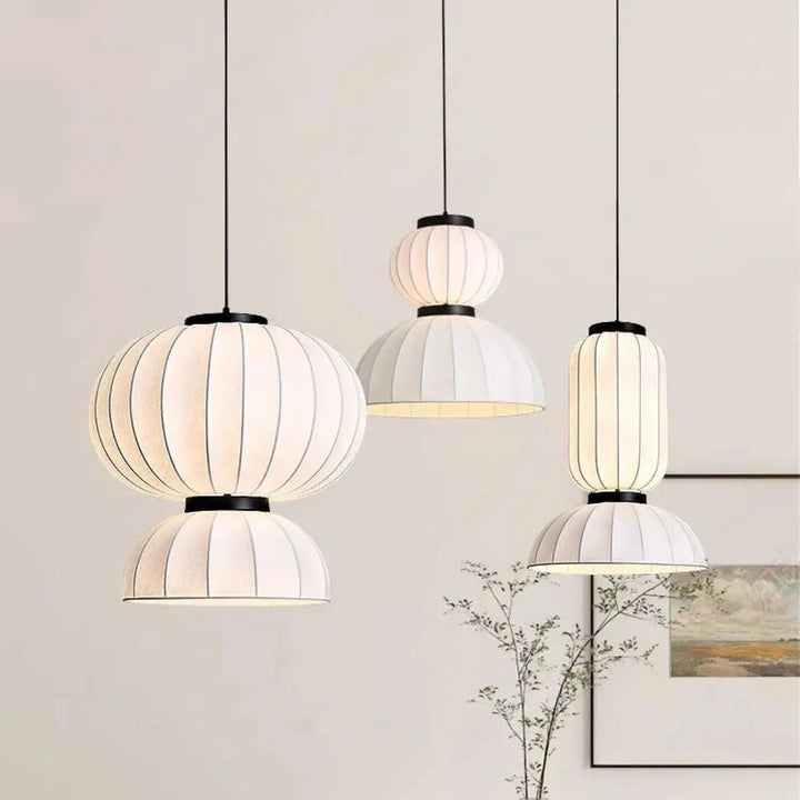 Suspension luminaire dualis avec trois suspensions blanches plissées en formes superposées et armature métallique noire élégante