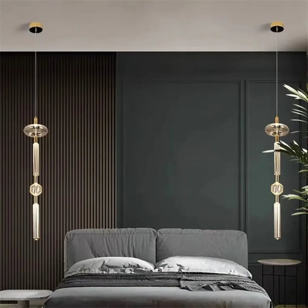 Suspension luminaire kylor avec pendentifs dorés et cristaux géométriques au-dessus d’un lit gris cipher multi