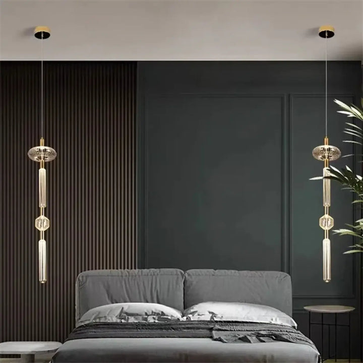 Suspension luminaire kylor avec pendentifs dorés et cristaux géométriques au-dessus d’un lit gris cipher multi