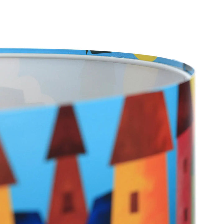 Suspension luminaire enfant cylindrique avec illustration colorée de bâtiments aux toits rouges sur fond bleu vif