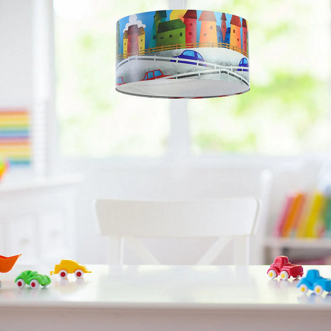Suspension luminaire enfant multicolore avec abat-jour cylindrique illustrant une ville colorée et voitures jouets