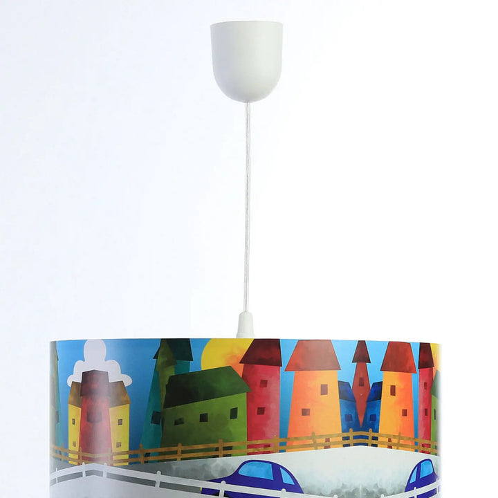 Suspension luminaire enfant multicolore avec abat-jour cylindrique illustré de maisons et voitures stylisées sur ciel bleu