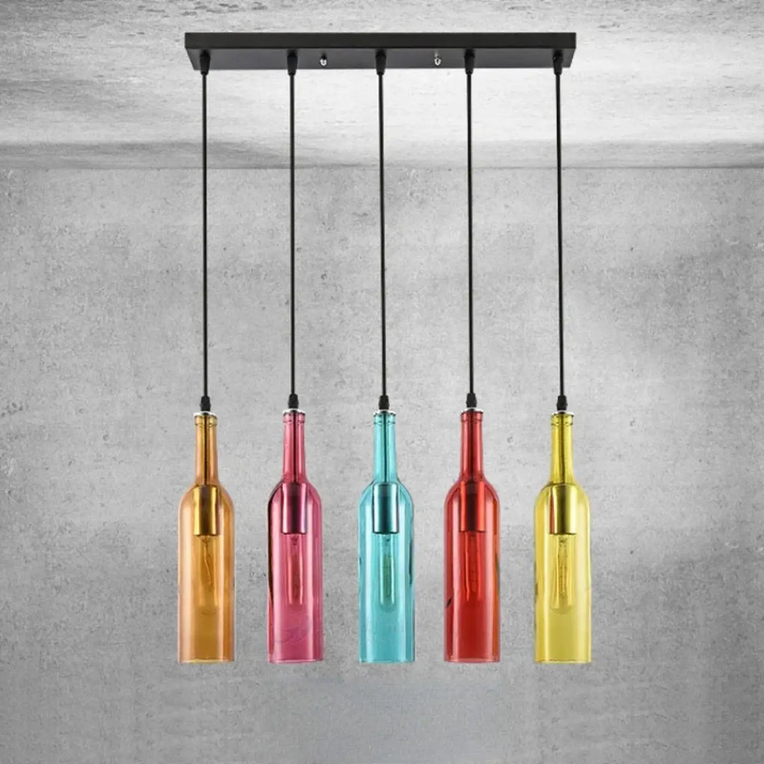 Suspension luminaire aria avec cinq bouteilles colorées en verre amber, rose, teal, rouge et jaune suspendues sur barre métal noir