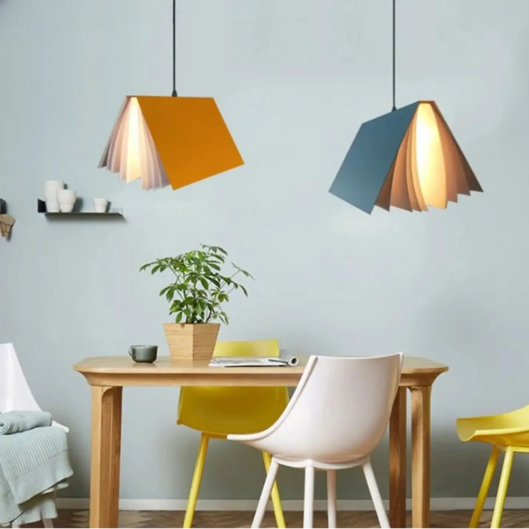 Deux suspensions luminaires boky en forme de livre ouvert transforme avec couvertures orange et bleue et pages en papier diffusant une lumière chaude