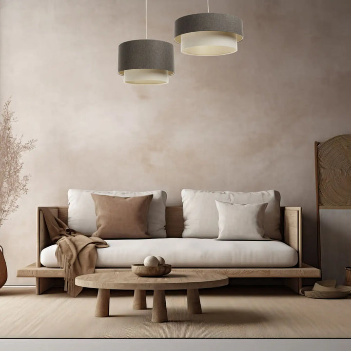 Minimalist wooden coffee table with three sturdy legs and smooth round top paired with suspension luminaire graphite duo boho elegant in crème and ecru
