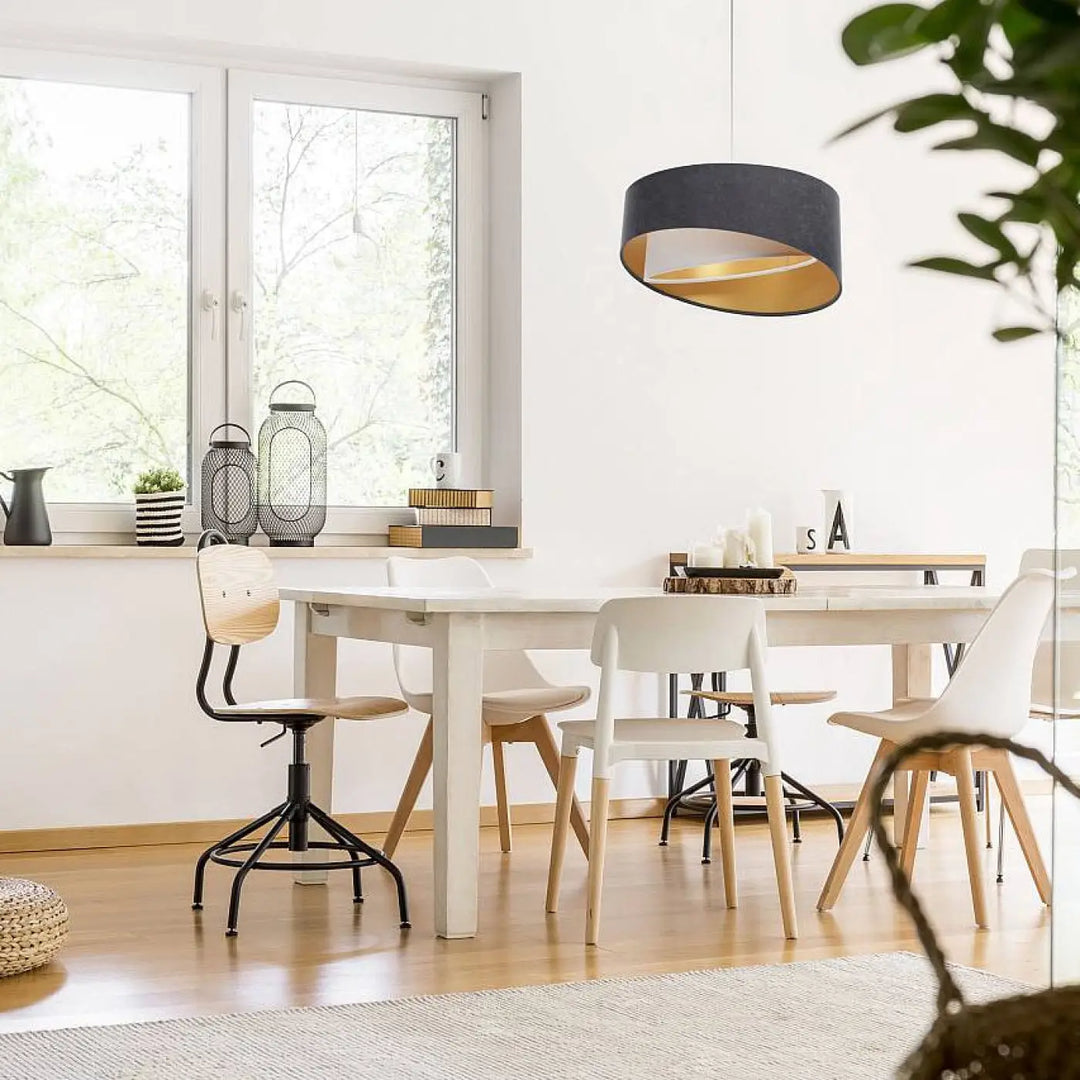 Suspension luminaire graphite galaxy auric avec abat-jour cylindrique noir et or au style velours chic au-dessus de la table à manger