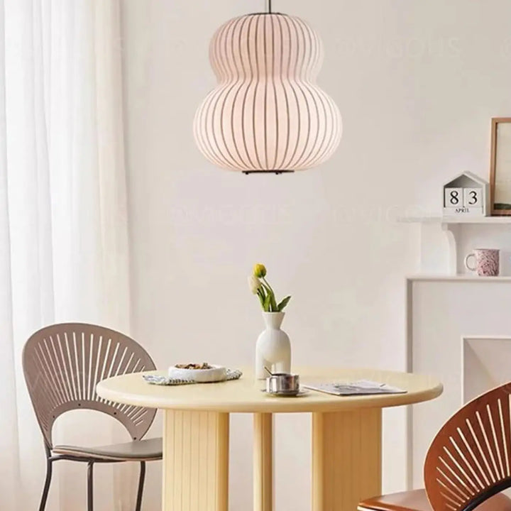Suspension luminaire japonaise shoyo en rose poudré côtelé avec design en forme de gourde suspendue au-dessus de la table
