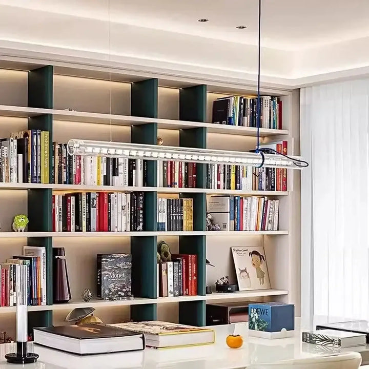 Suspension luminaire nushia en verre soufflé avec câble tressé minimaliste au-dessus dune bibliothèque