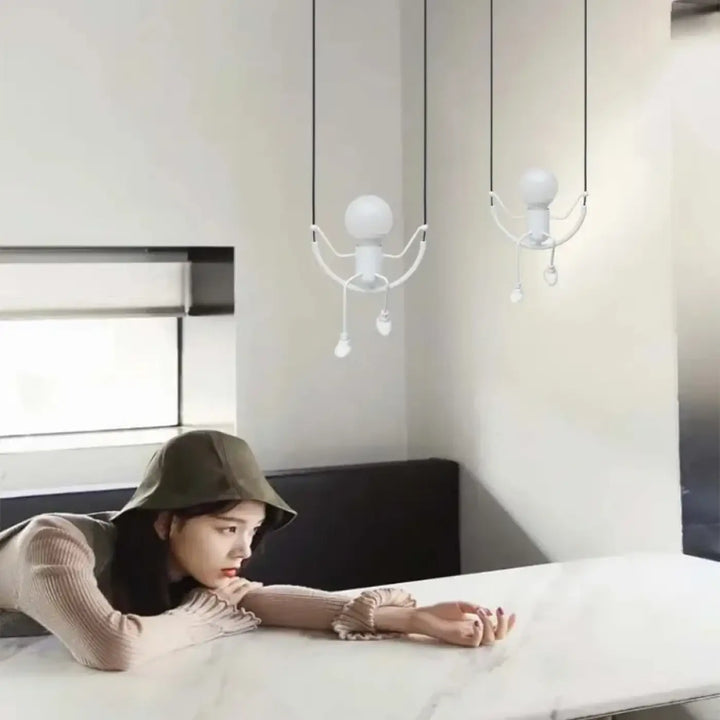 Deux suspensions luminaires blanches minimalistes au design ludique articulé suspendues par des câbles noirs