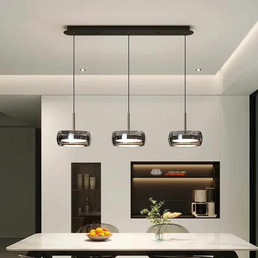 Trois luminaires suspension simpa avec abat-jours en verre transparent et fixations métalliques noires modernes suspendus au plafond minimaliste