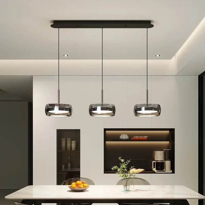 Trois luminaires suspension simpa avec abat-jours en verre transparent et fixations métalliques noires modernes suspendus au plafond minimaliste