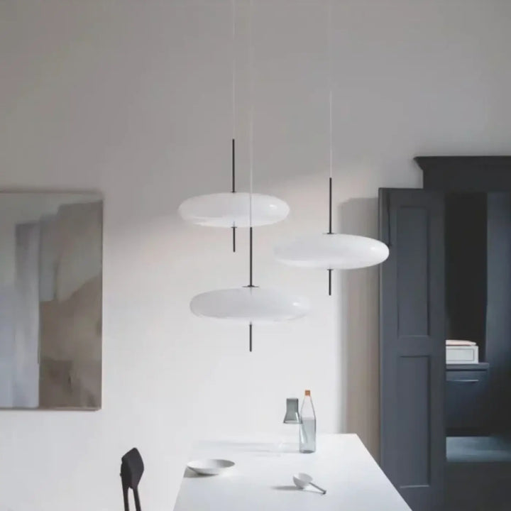 Suspension luminaire minimaliste blanca blanc en forme de disque avec tiges noires fines design sculptural idée cadeau