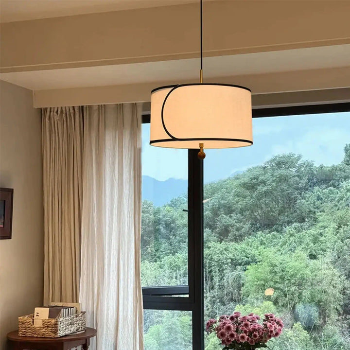 Suspension luminaire avril crème cylindrique avec bordure noire et motif lune subtile en forme de croissant