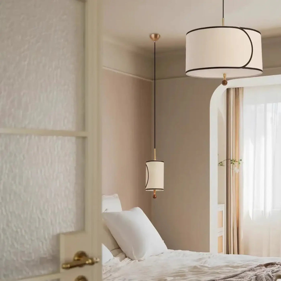Suspension luminaire avril avec abat-jour cylindrique en tissu blanc, bordure noire et ferrure métal doré