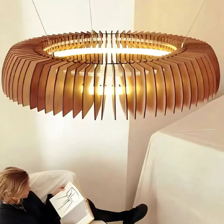 Suspension luminaire xylia avec lames de bois en couches et anneau lumineux central pour salle d’exposition chaleureuse